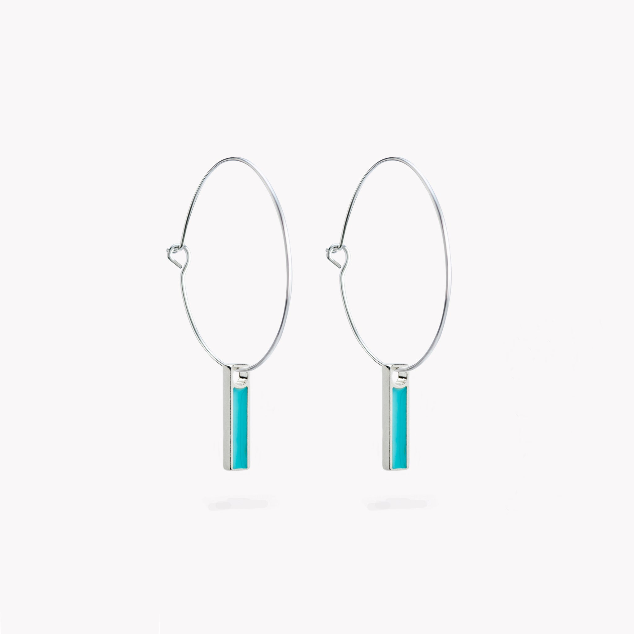A pair of simple hoop earrings with a hanging turquoise bar.