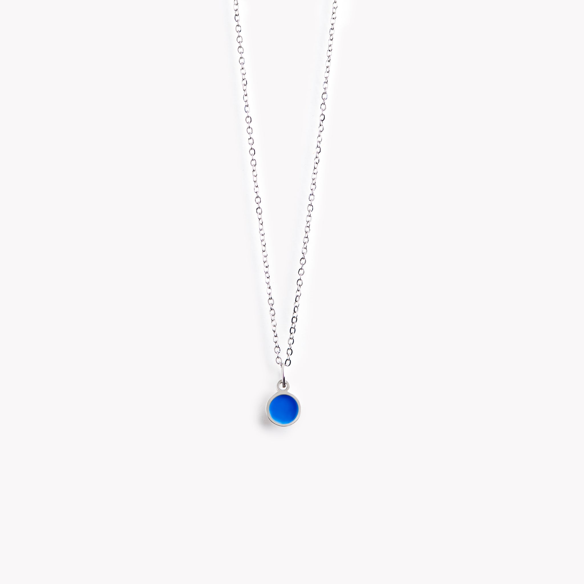 A simple, delicate, circular necklace with a bright blue centre and a polished pewter surround.