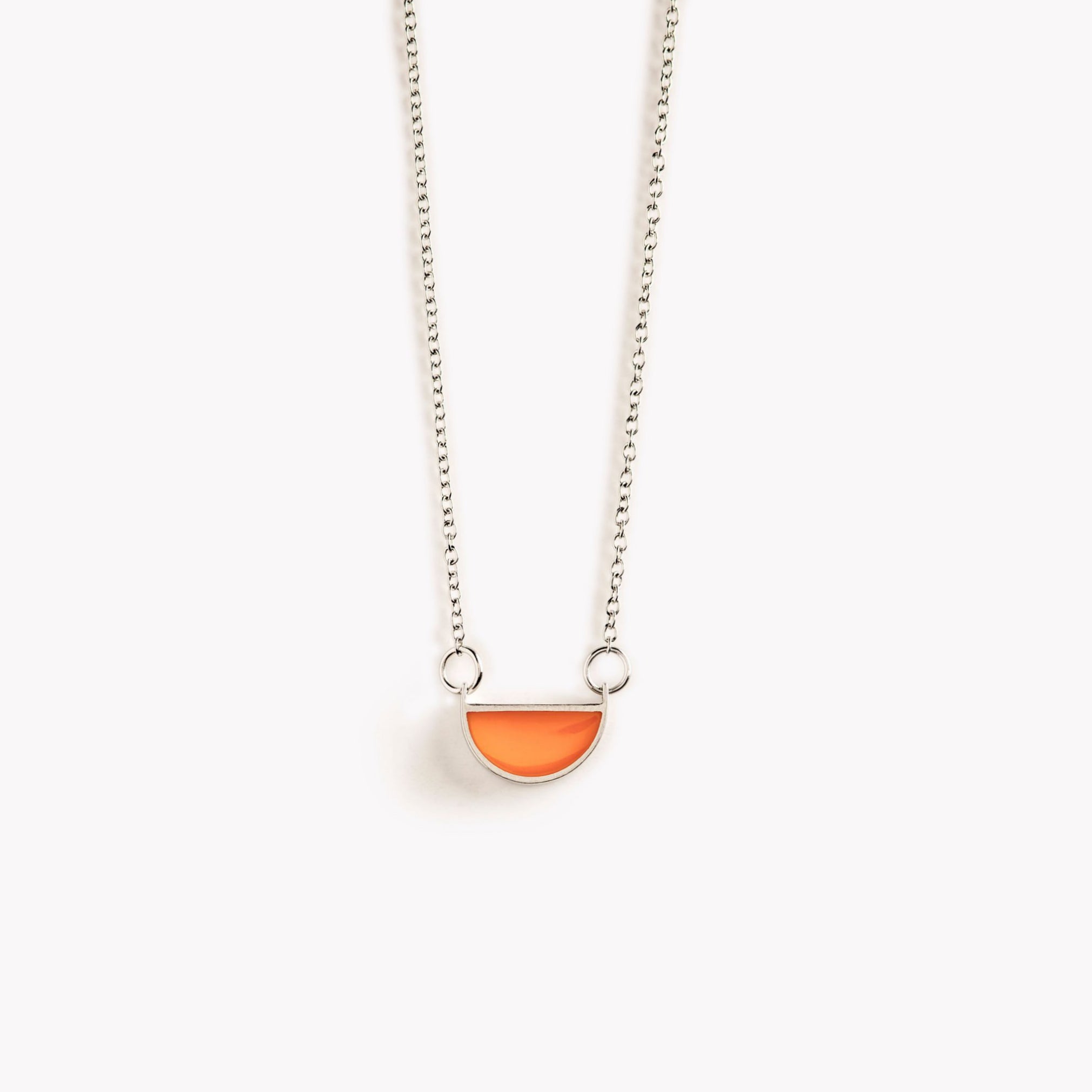 A simple, bright orange, half circle shaped pendant necklace.