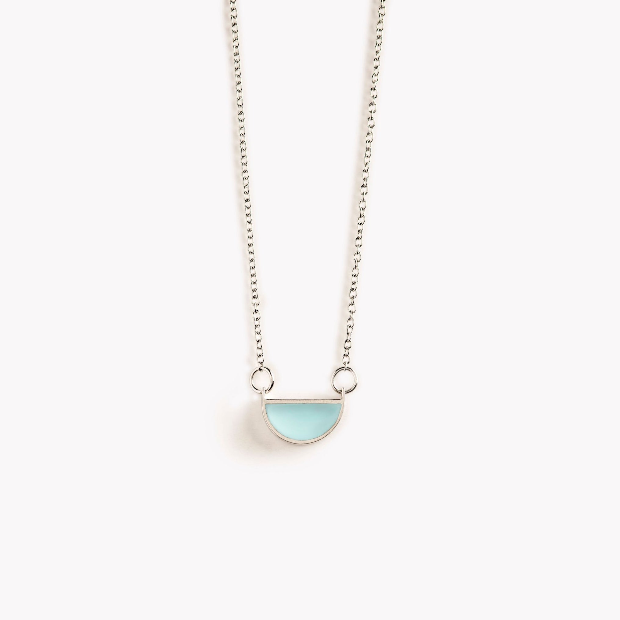 A simple, pale turquoise, half circle shaped pendant necklace.