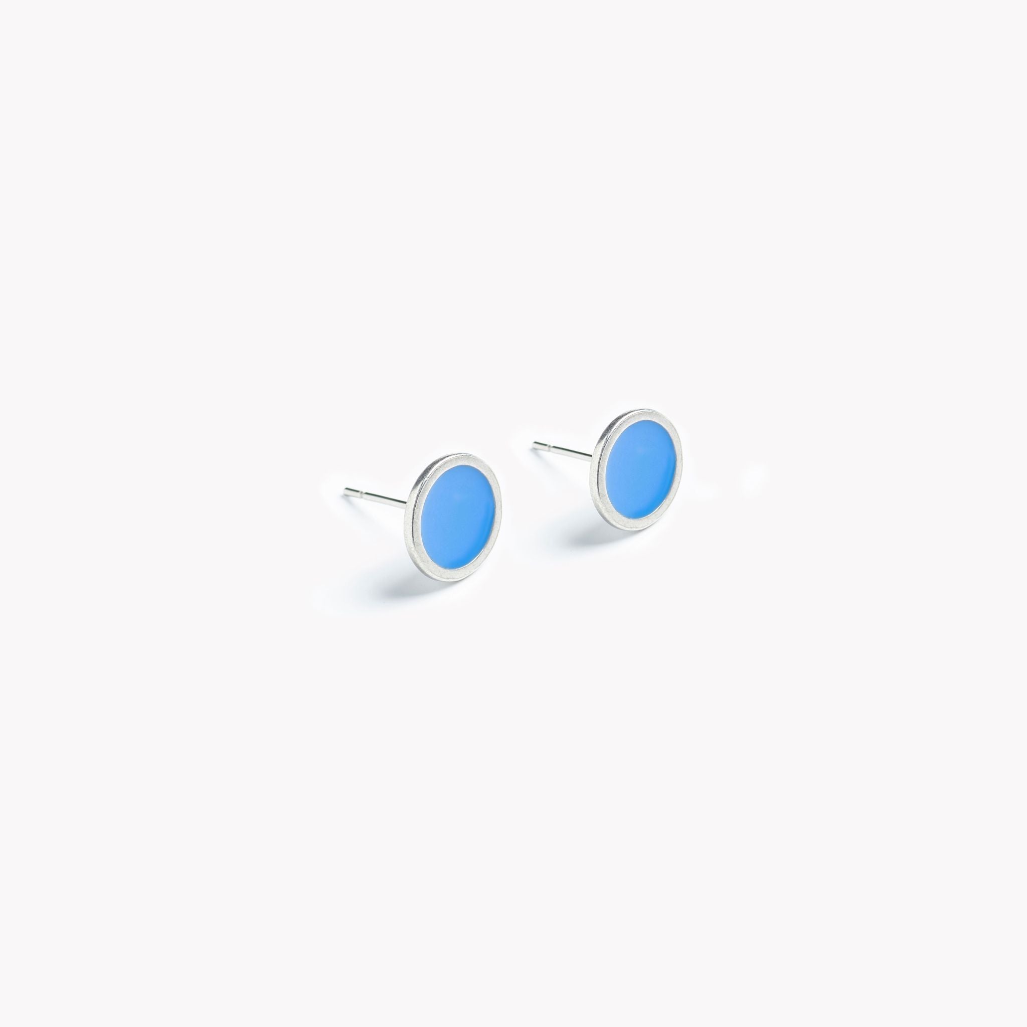 A simple pair of bright blue circular stud earrings.