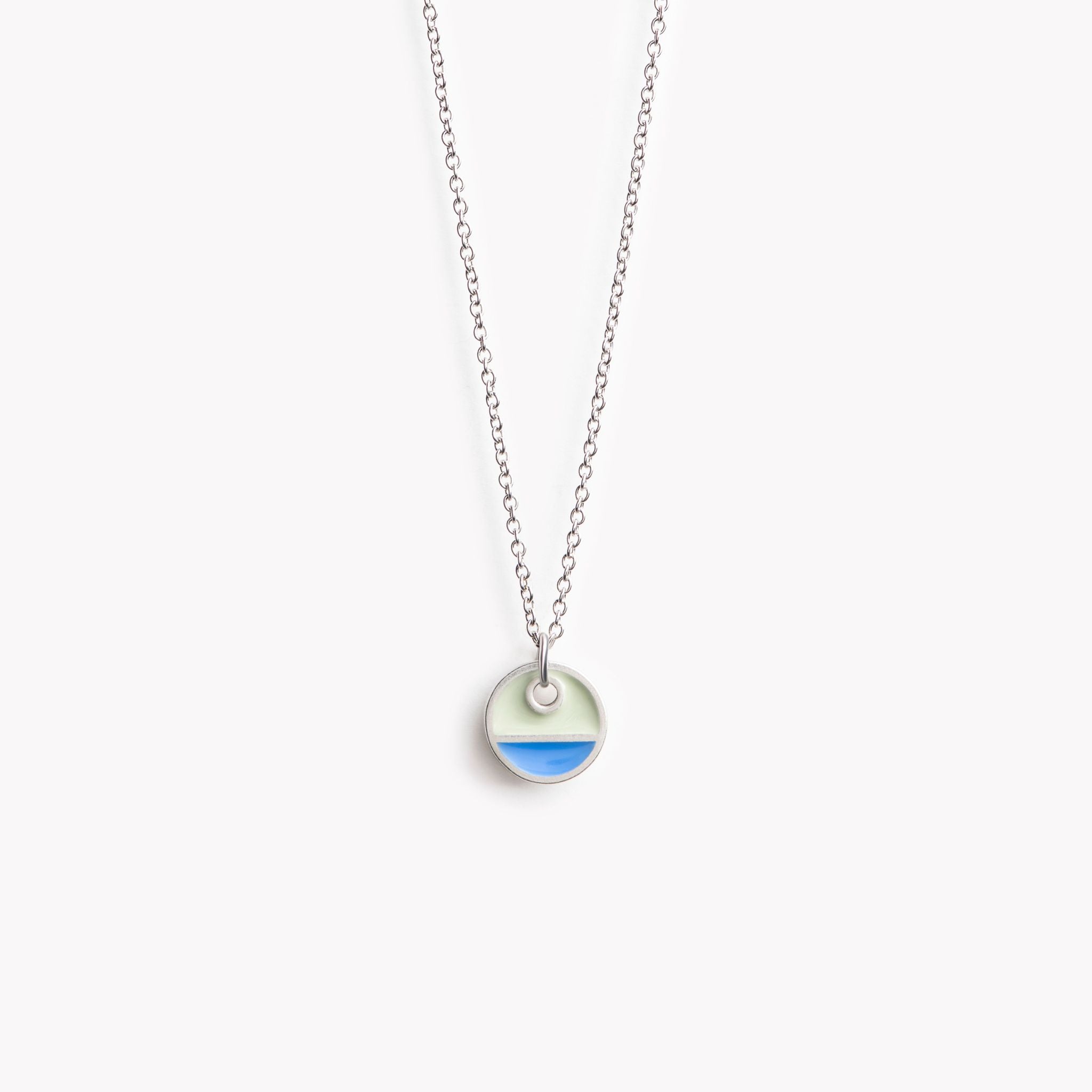 A simple circular pendant necklace with a horizontal division. In blue and grey.