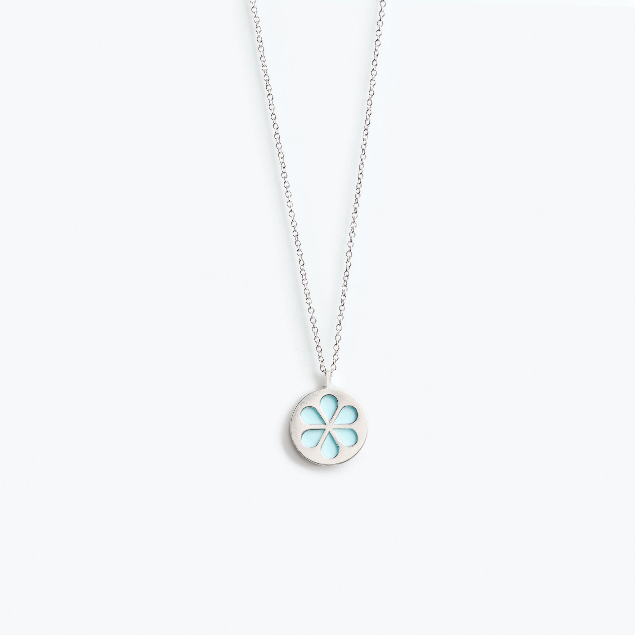 A simple pale turquoise flower pendant necklace, mounted on a fine trace chain.