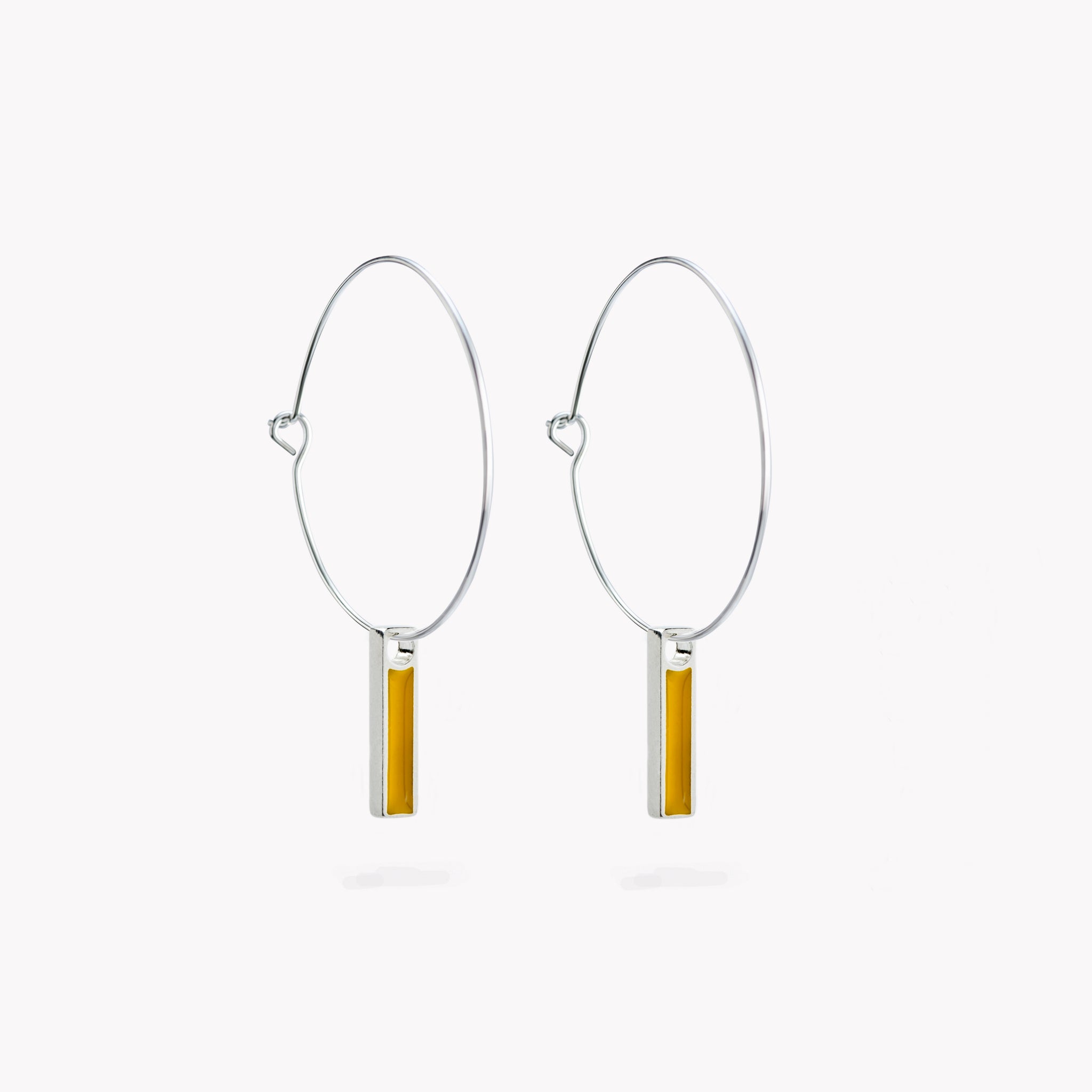 A pair of simple hoop earrings with a hanging yellow bar.