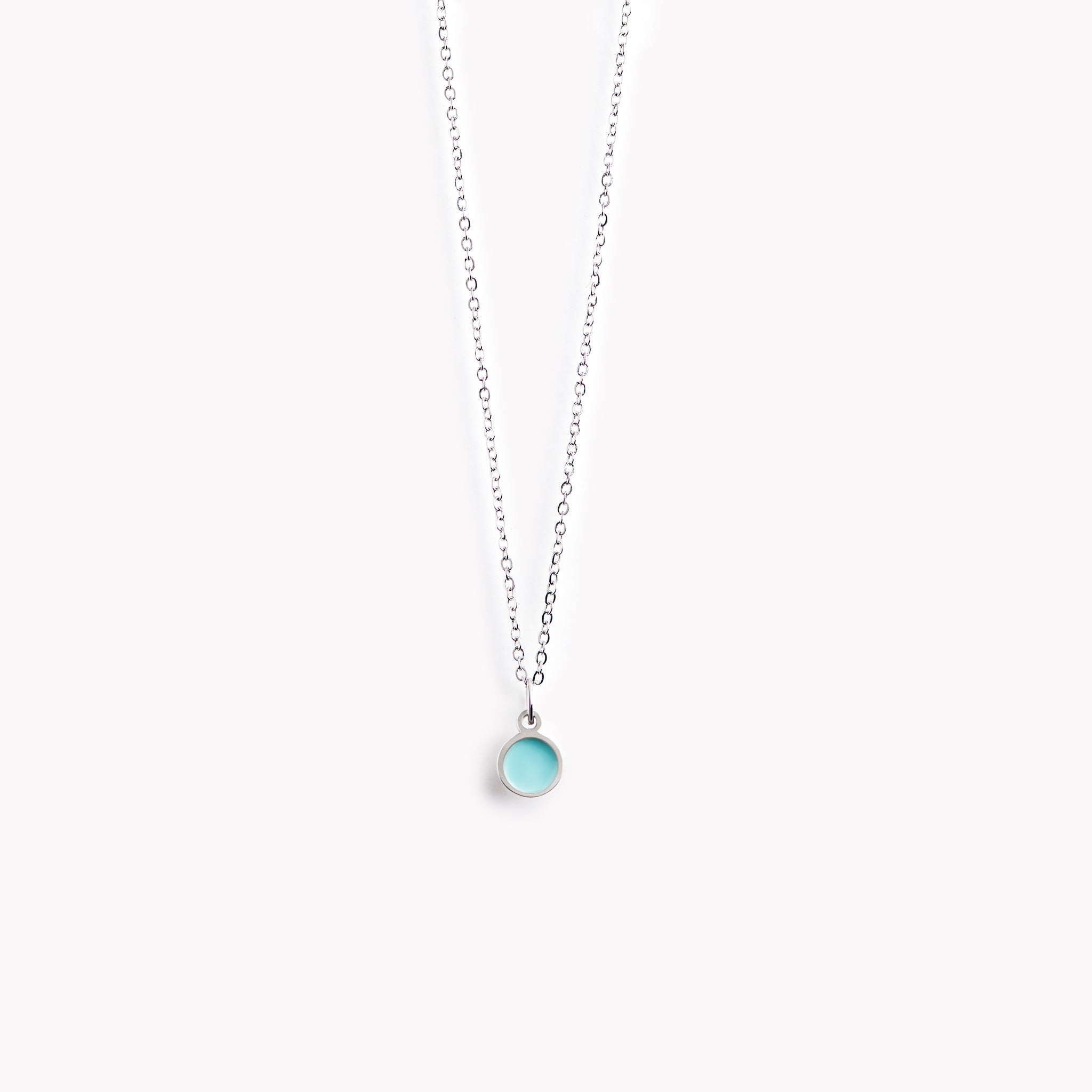 A simple, delicate, circular necklace with a light turquoise centre and a polished pewter surround.