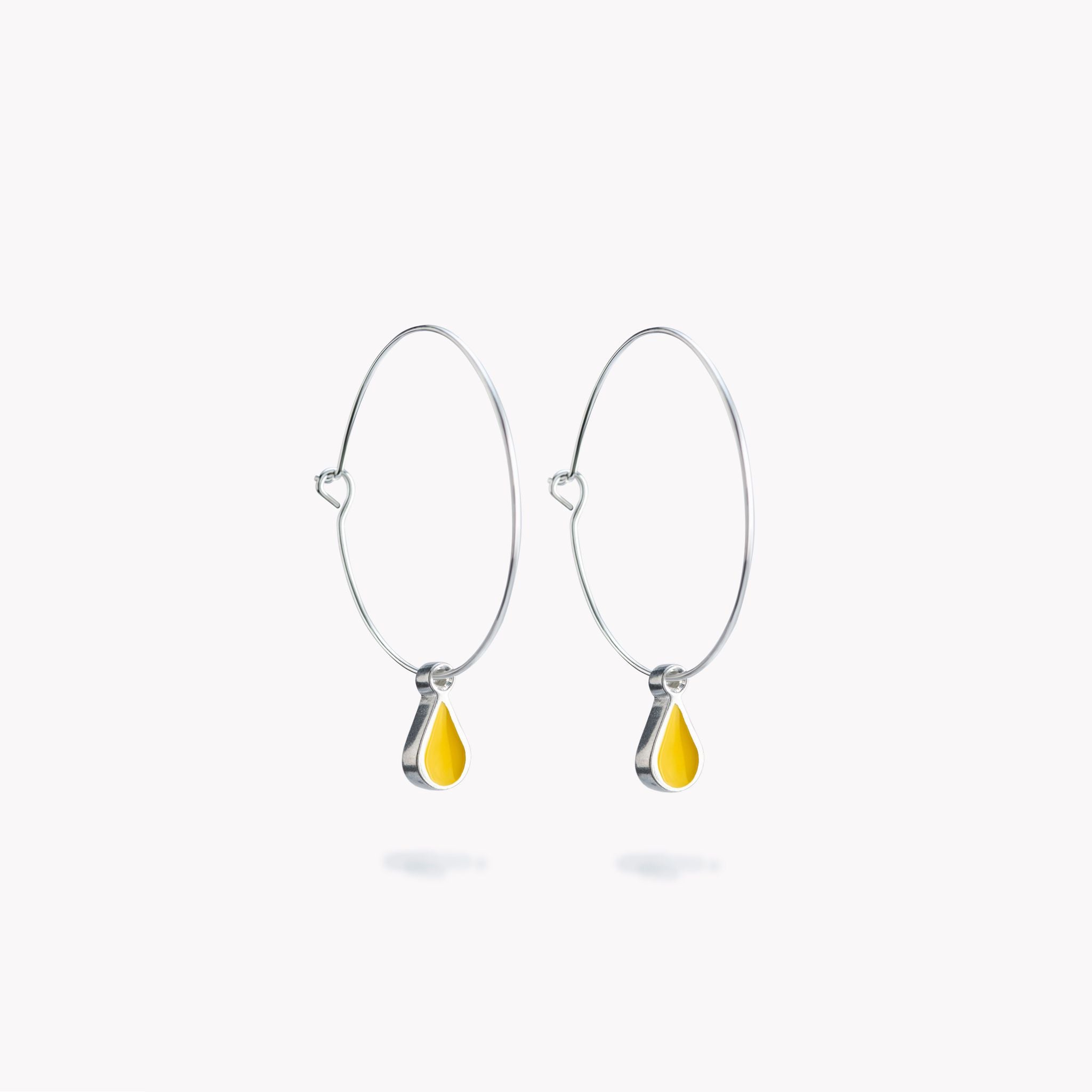 A simple pair of hoop earrings with yellow hanging droplets.