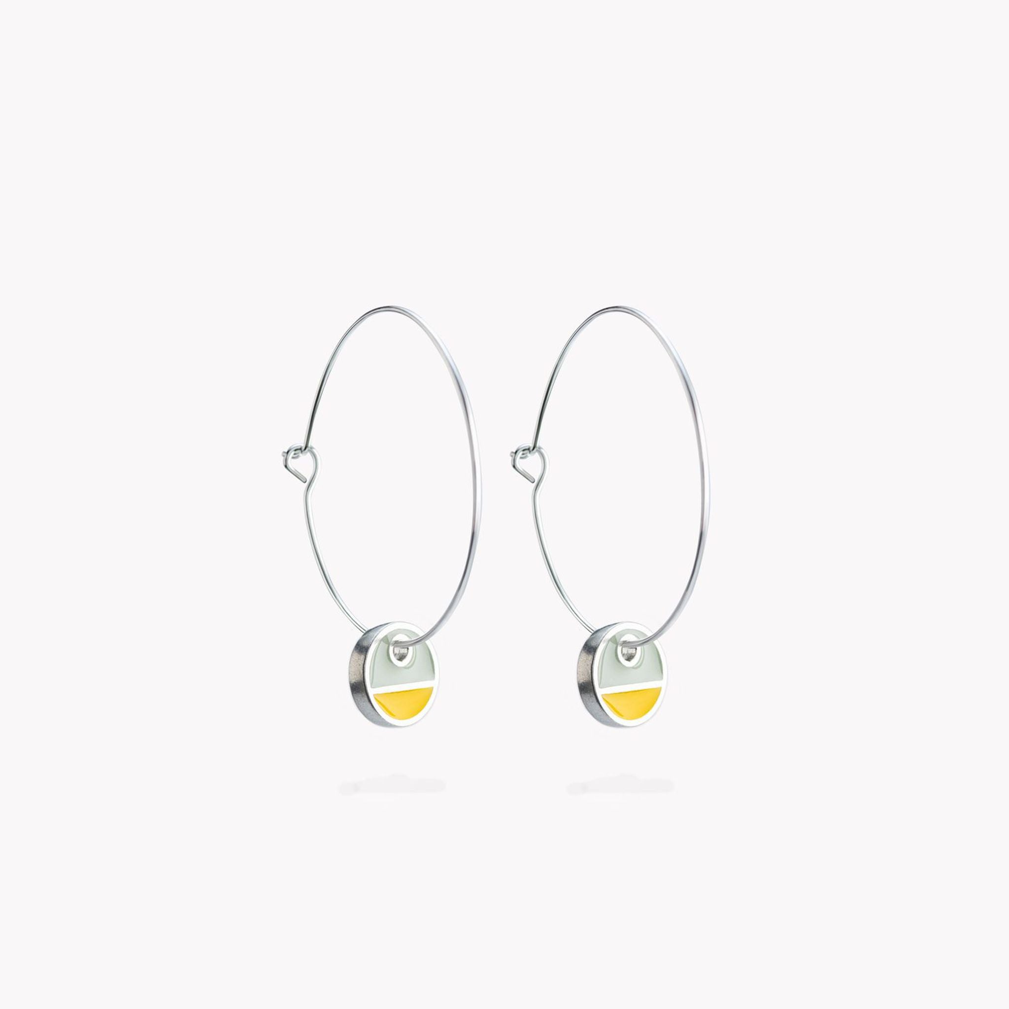 A simple pair of hoop earrings with yellow and grey circular hanging discs.