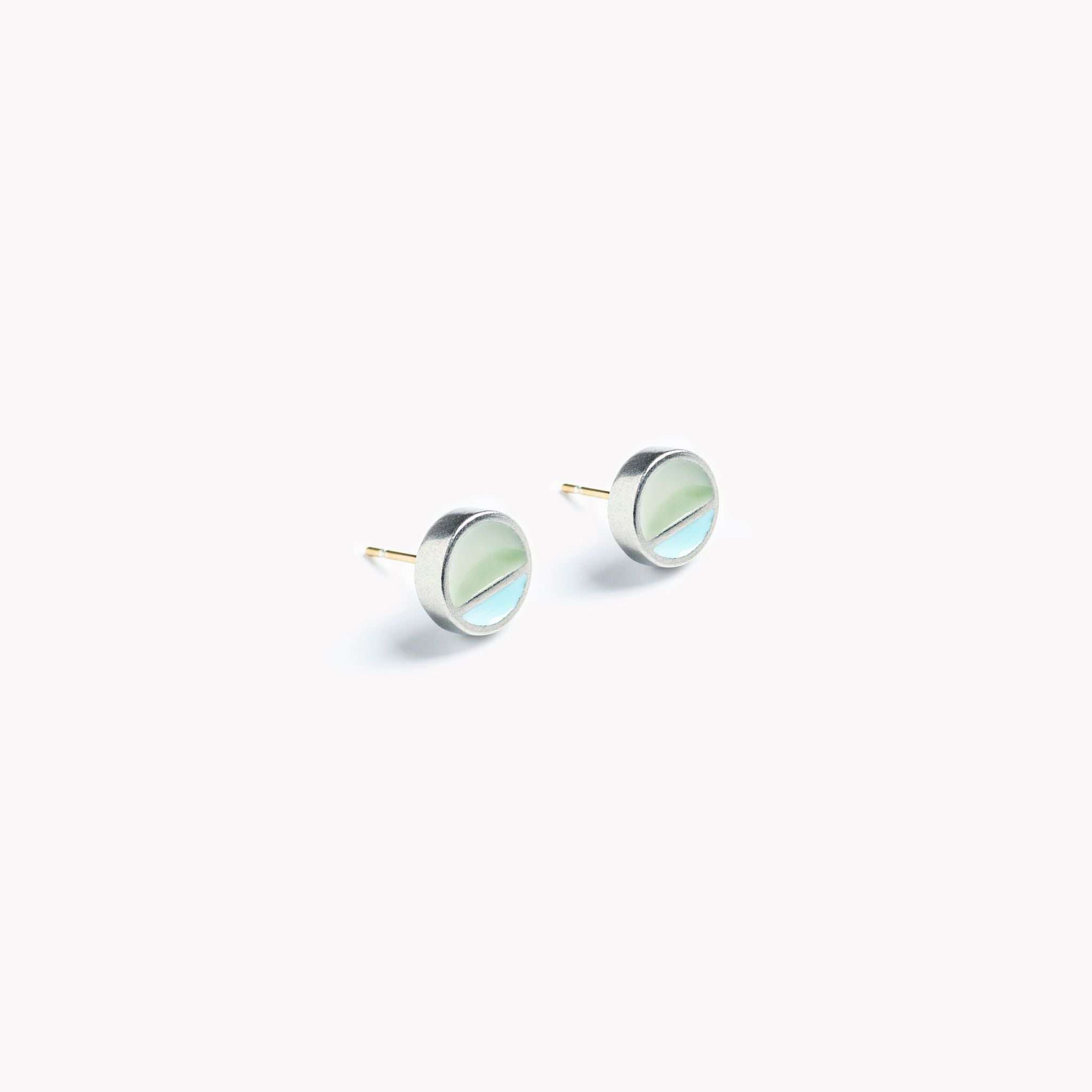 A simple pair of circular stud earrings with a horizontal division. In turquoise and grey.