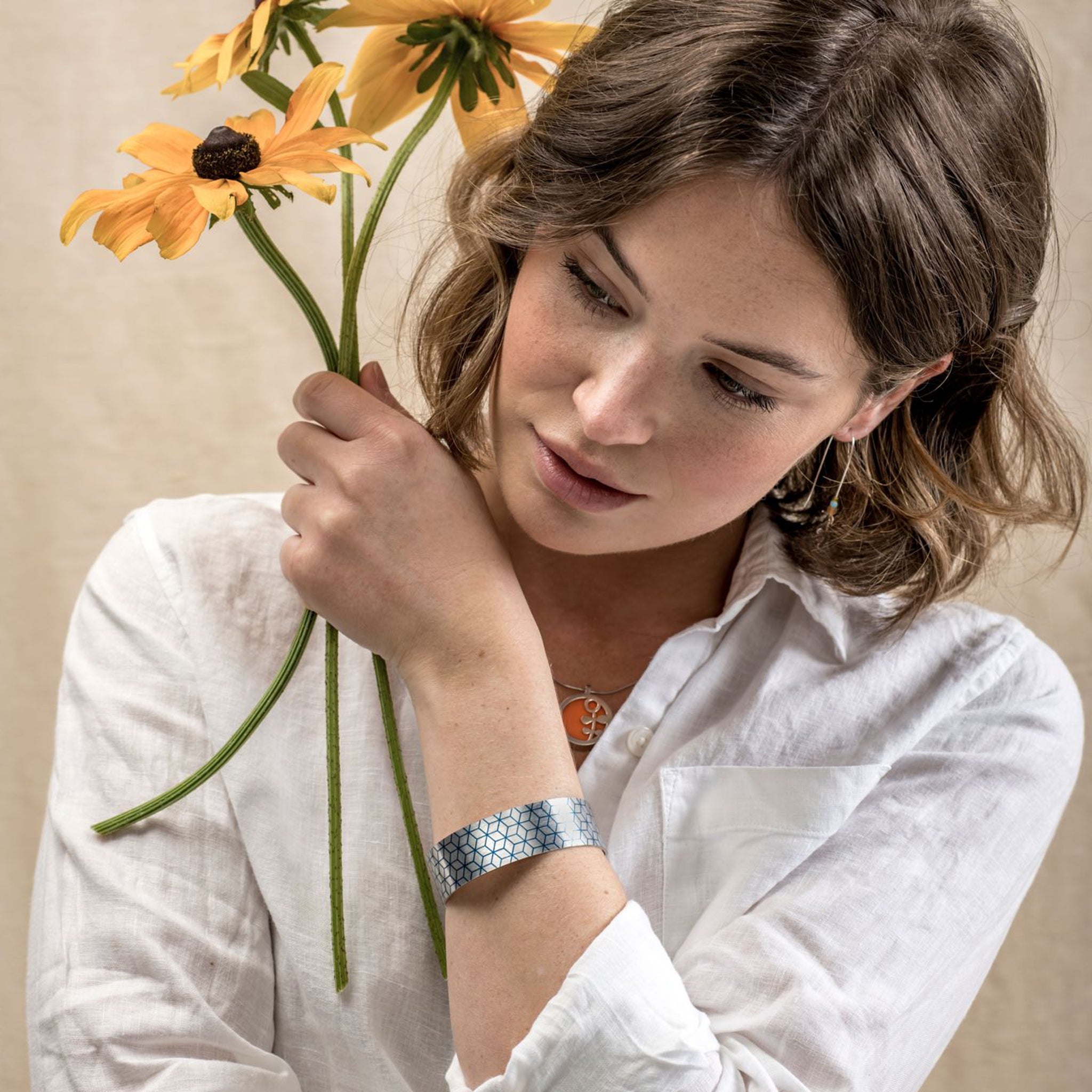 Fashion model wearing an intricate cuff bracelet with a geometric pattern.
