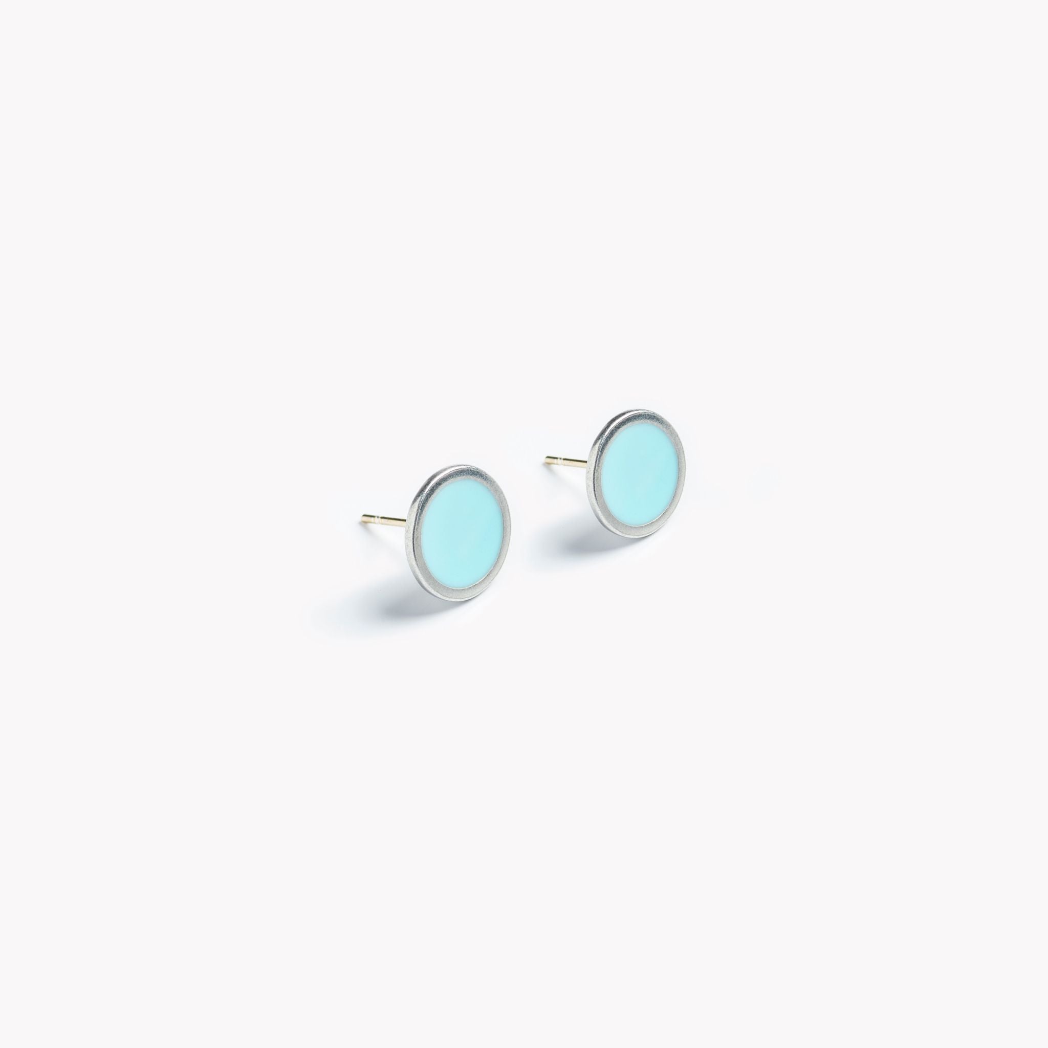 A simple pair of pale turquoise circular stud earrings.