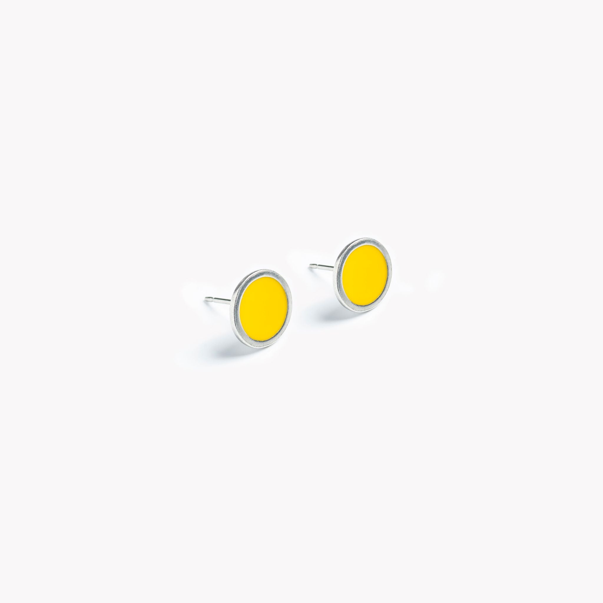 A simple pair of bright yellow circular stud earrings.