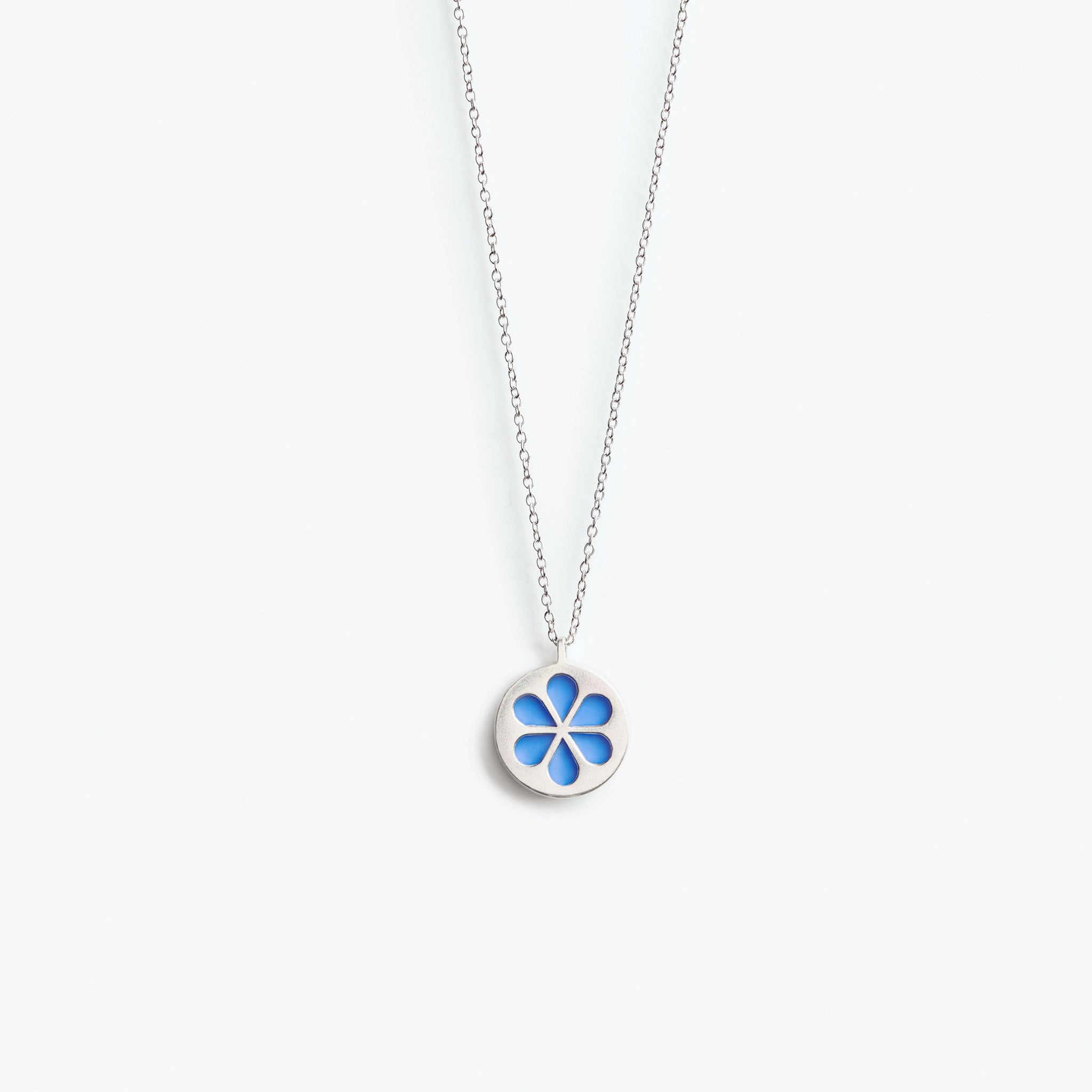A simple bright blue flower pendant necklace, mounted on a fine trace chain.